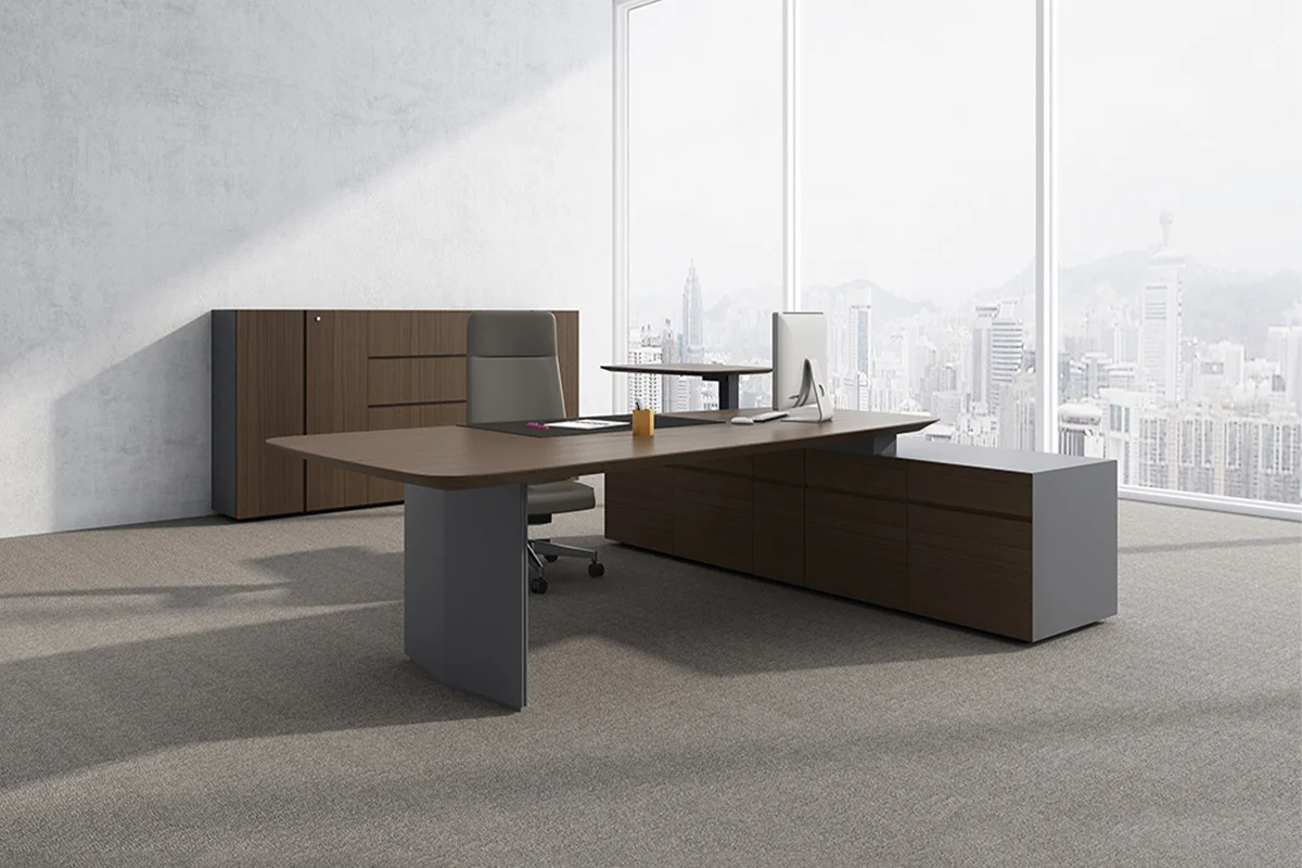 Modern executive office with a large U shaped wooden desk gray chair and dark wood filing cabinet against a concrete wall and city skyline windows