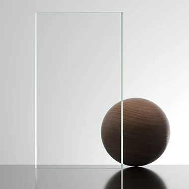 Wooden sphere balanced beside a tall clear glass panel on a reflective surface