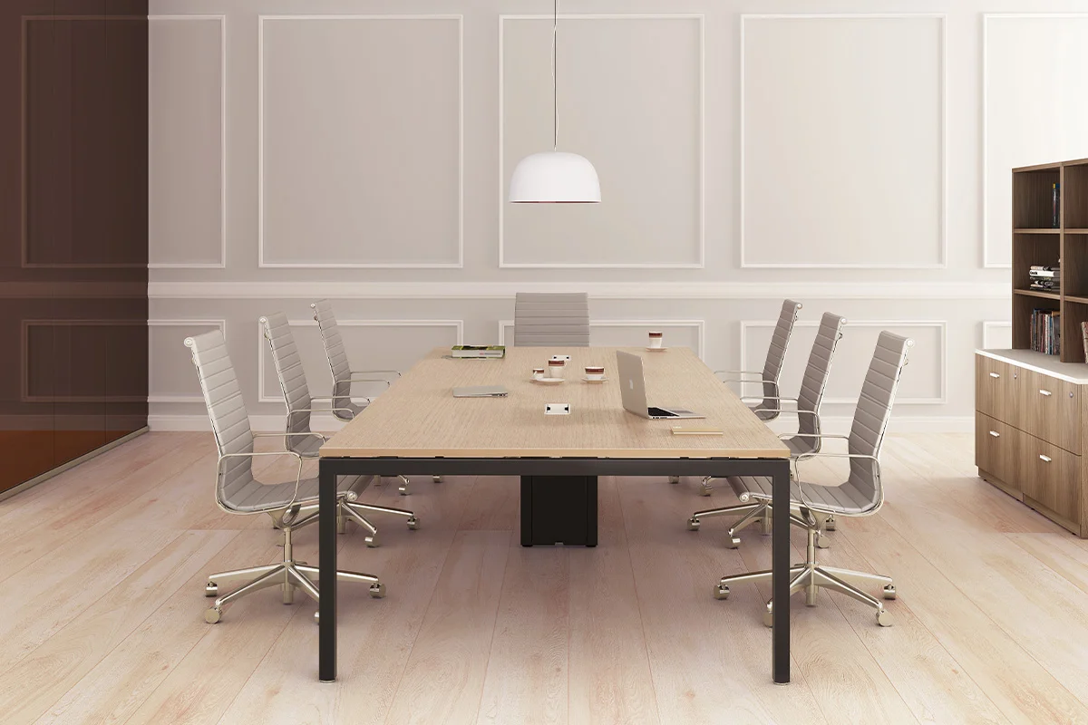 Modern conference room with a long light-wood table, white swivel chairs, and a suspended white pendant light above the center.