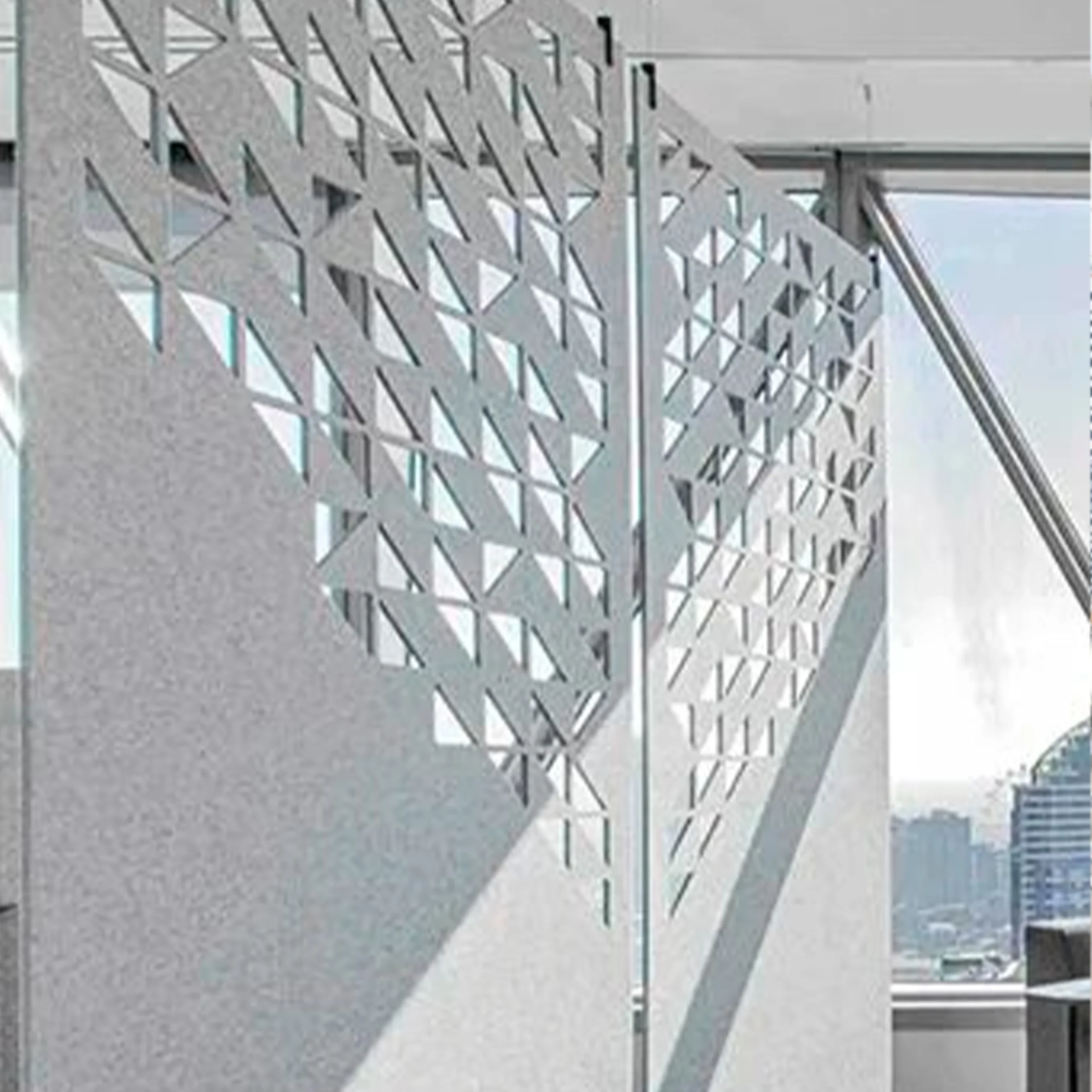 Close-up of a modern building facade with a diamond-shaped perforated metal screen overlaying the exterior wall.