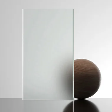 Transparent glass panel standing upright on a reflective surface beside a small dark wooden sphere creating a minimal still life composition