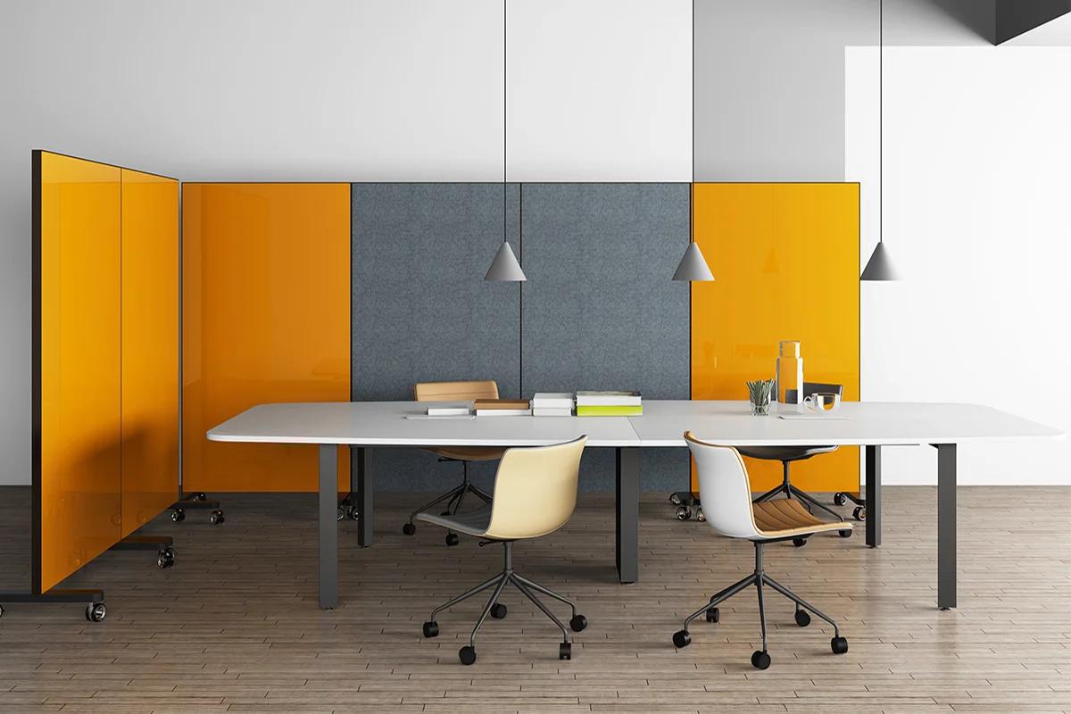 Modern conference room with a long white table, orange and gray acoustic panels, and swivel chairs on a wooden floor.
