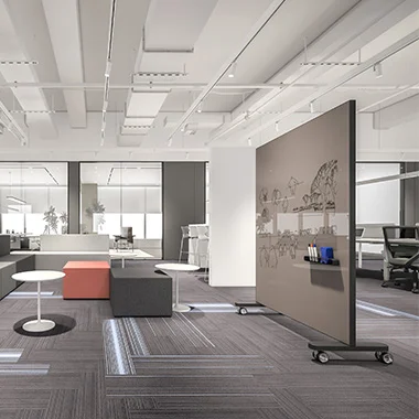 Open office space with white ceiling, seating area, and a movable partition on wheels featuring a graphic mural.