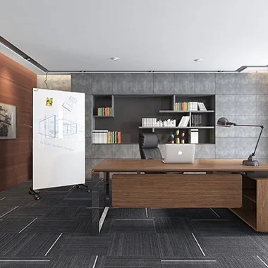 Modern office with a large wooden desk, laptop, adjustable lamp, and built-in gray shelving; whiteboard on the left.