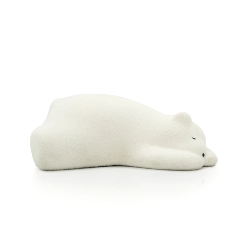 White plush toy bear lying on its side appearing asleep on a white background