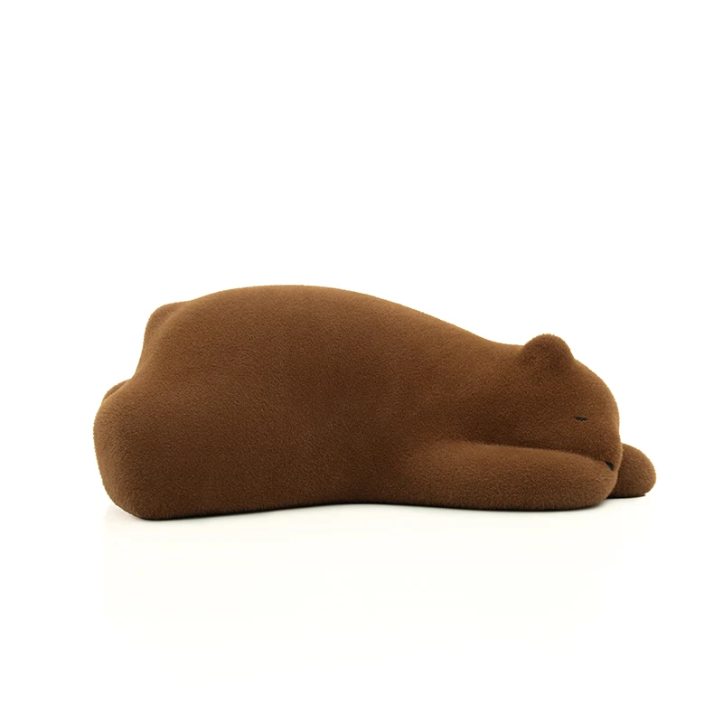 Brown plush toy shaped like a sleeping animal lying on its side on a white background