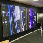 gp cabling solutoin center junho 2026 58 | gpcablingcombr Large wall mounted display showing a close up of server rack with blue and purple cables in a tech room