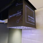 gp cabling solutoin center junho 2026 67 | gpcablingcombr LED lit black cubic sign hanging from a ceiling showing ONE STOP SHOP and DESIGN in bluewhite text