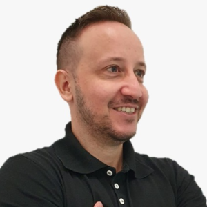 Portrait of a smiling man with arms crossed wearing a black polo shirt and a wristwatch