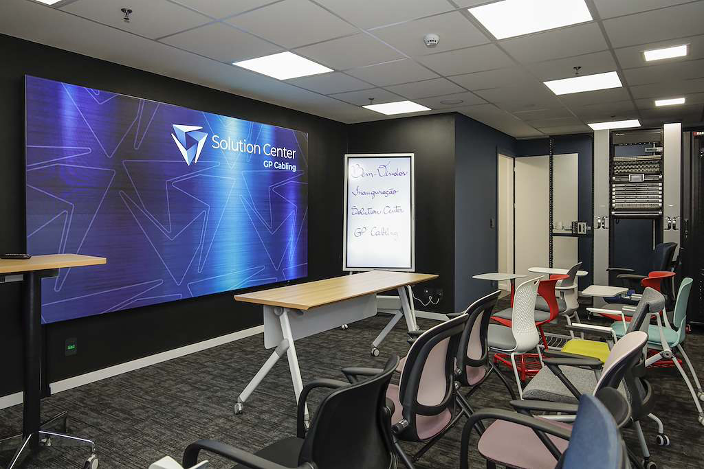 Training room with a blue 'Solution Center' banner, whiteboard, and classroom seating for a presentation or training session at a tech center.