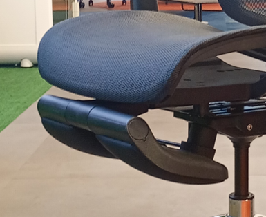 Close-up of a blue upholstered office chair seat, showing the underside mechanism and gas lift.