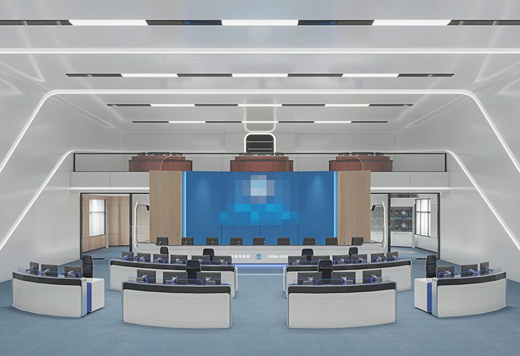 Futuristic conference hall with a central stage, a blue backdrop screen, and curved seating facing the stage.