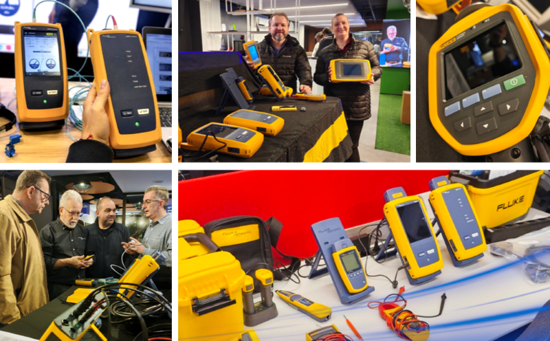 Three yellow handheld diagnostic devices on a table at a tradeshow one being held for a closer look screens showing data